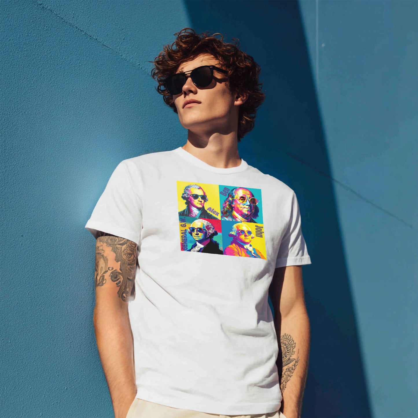 Man wearing sunglasses and a white graphic tee with an image of pop art style founding fathers wearing sunglasses