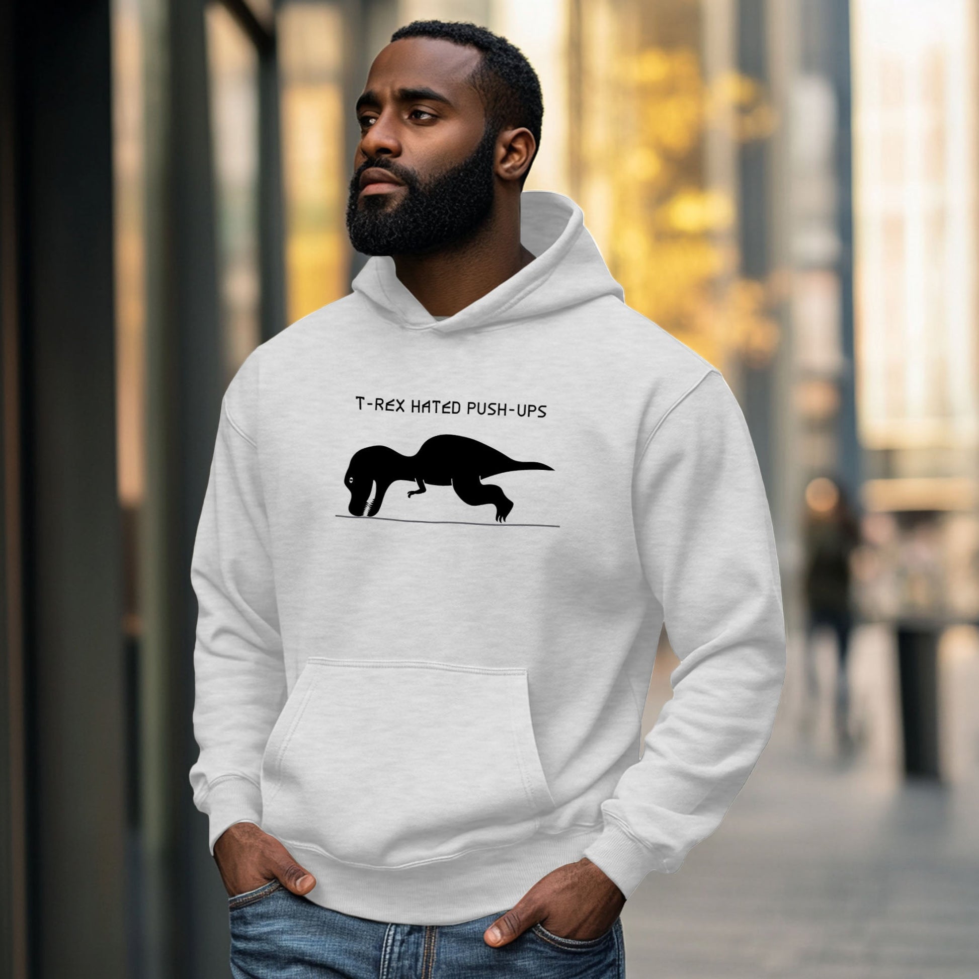 Man wearing a white hoodie with a graphic of a T-Rex trying to do a push-up
