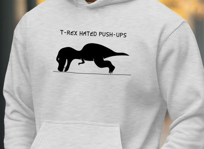 white hoodie with a graphic of a T-Rex trying to do a push-up